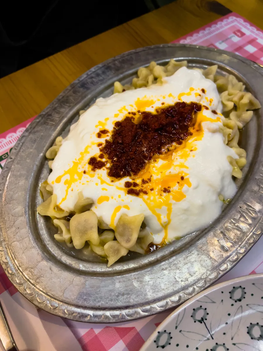 Metal tabakta yoğurtlu ve biber soslu mantı