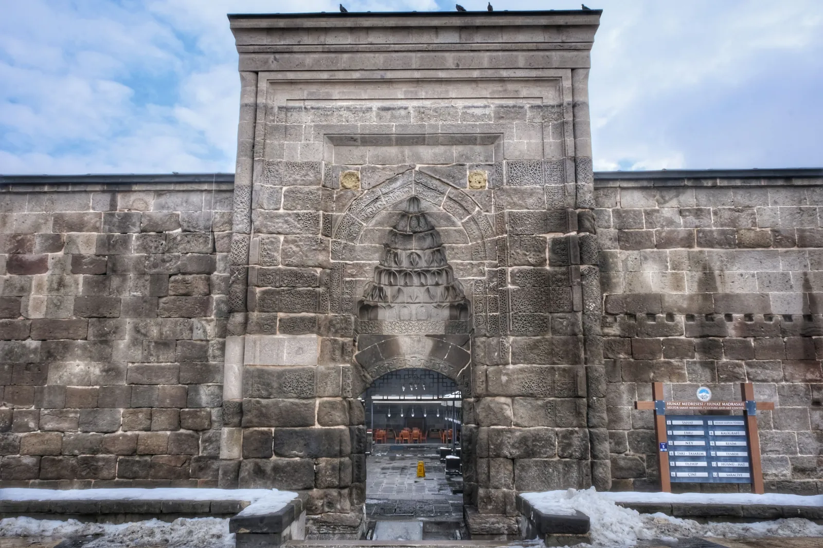 Kayseri'de taş işlemeli tarihî bir taç kapı, önünde kar