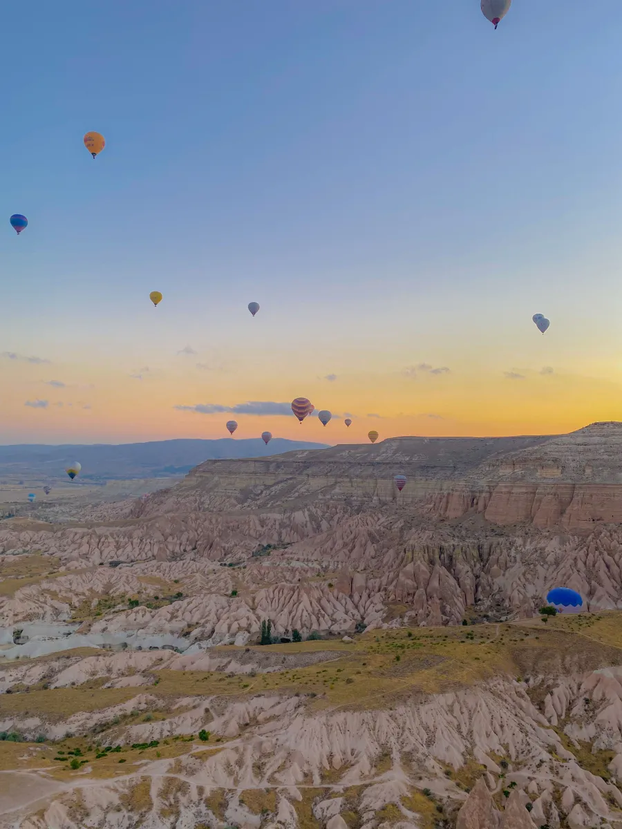 Gün doğumunda Kapadokya vadileri üzerinde sıcak hava balonları