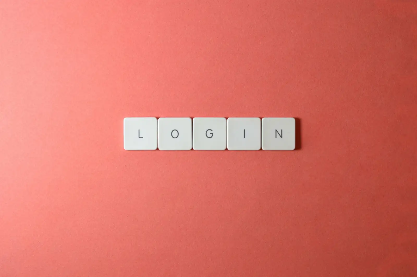 Mercan rengi zemin üzerinde LOGIN yazan beş beyaz klavye tuşu